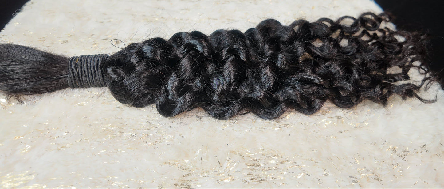 Braided black hair extensions on a textured white surface with a dark background